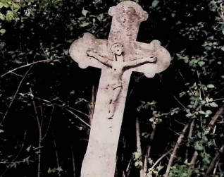 Nagrobek z krzyżem na zwężającym się cokole. Krzyż ma ramiona zakończone trójliściem i relief Chrystusa z czaszką i piszczelami. Cokół ma ścięte krawędzie i inskrypcję.