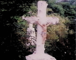 Nagrobek z krzyżem stylizowanym na pień drzewa na cokole z poziomych belek i dwustopniowej podstawie, z figurą Chrystusa. Cokół ma czterospadową, profilowaną płytę wierzchnią i prostokątną tablicę inskrypcyjną.