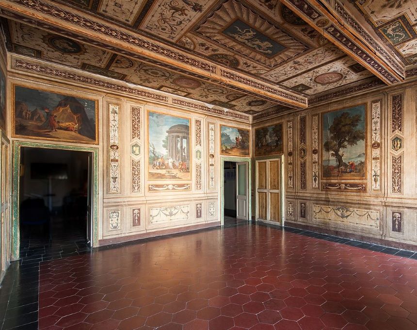 Interior of a room with frescoes by Tadeusz Kuntze on the walls and ceiling. The frescoes depict classical scenes and decorative motifs. The floor is covered with hexagonal tiles.
