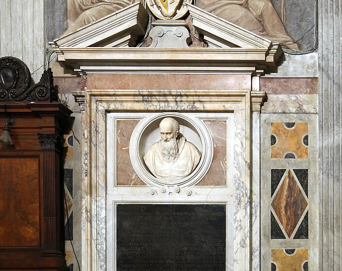 Tombeau du cardinal Stanisław Hozjusz à Santa Maria in Trastevere, Rome. Le tombeau présente un buste en marbre de Hozjusz dans une niche ovale, avec une inscription en dessous et des éléments décoratifs autour.
