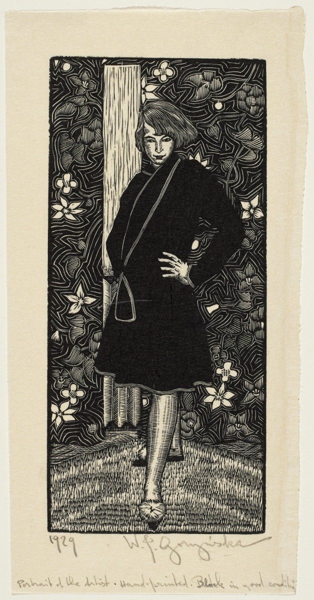 Woodcut print by Wiktorja J. Goryńska titled 'Portrait of the Artist' from 1929. It depicts a woman standing with one hand on her hip against a floral patterned background.