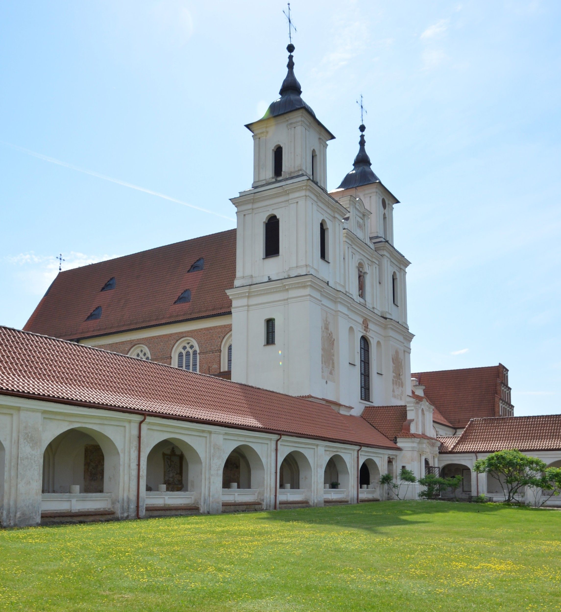 The Bernardine church and monastery in Cytowiany with two towers, surrounded by arcaded cloisters and a green lawn.