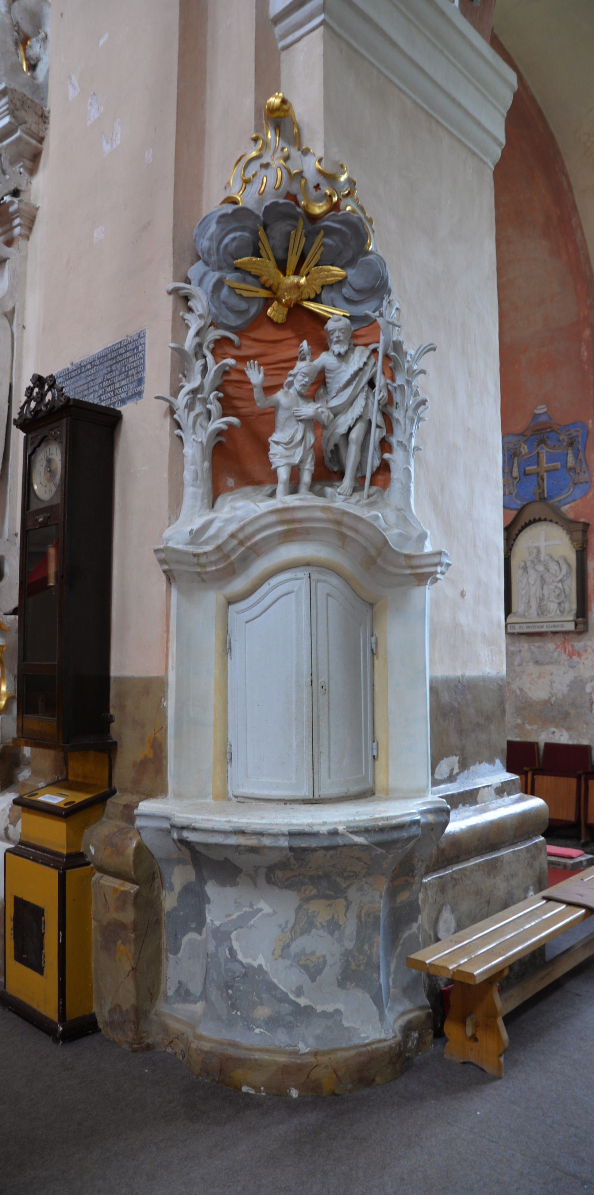 Interior of the Bernardine church in Cytowiany, featuring a baroque altar with a sculptural group depicting a biblical scene. The altar is adorned with gold and silver elements.