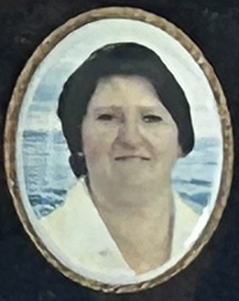 Oval portrait of a woman with dark hair and white blouse against a blue background.