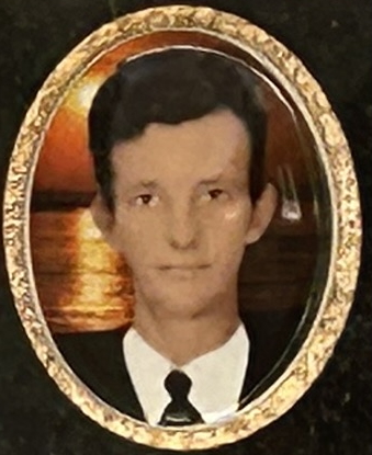 Portrait of a man in a suit against a sunset background, framed in an oval with a decorative frame.