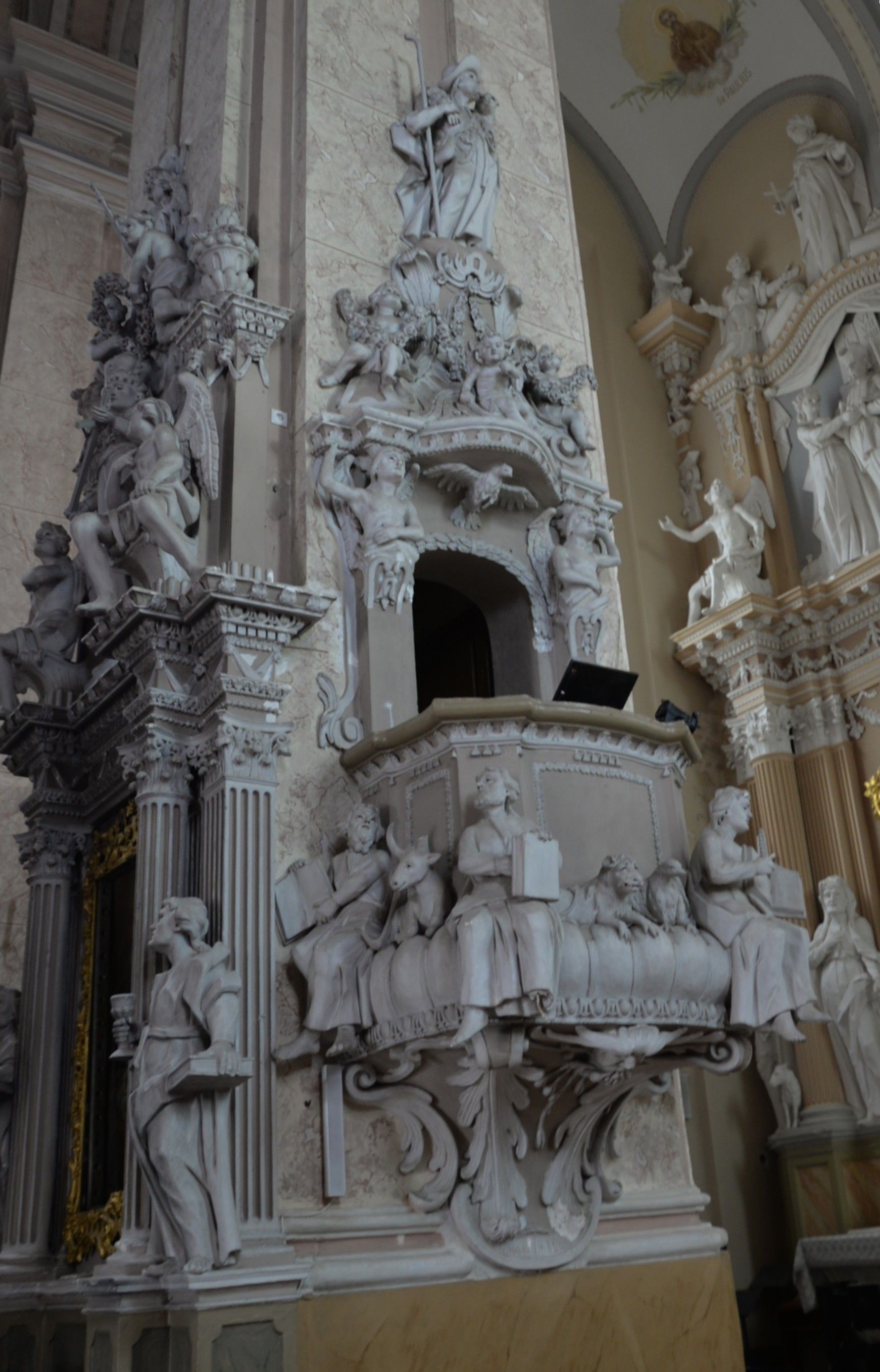 Intérieur de l'église de la Visitation de la Bienheureuse Vierge Marie à Szydłów, avec une chaire richement décorée de figures en stuc de saints et d'apôtres de style baroque.