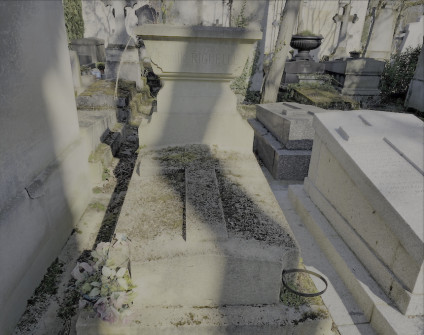 Nagrobek rodziny Riguelle i Edwarda Mirenowicza z cokolem schodkowym i krzyżem. Inskrypcja na żardiniery. Znajduje się na cmentarzu z otaczającymi grobami.