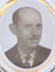 Black and white portrait of a man with a mustache, wearing a suit and tie, in an oval frame.