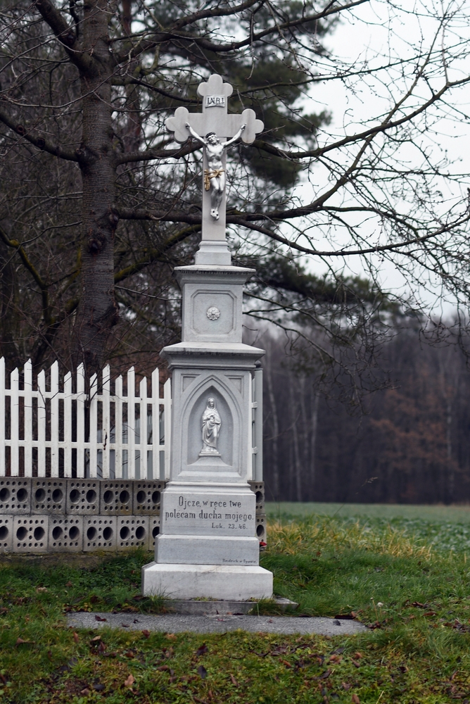 Roadside cross in the Czech part of Těšín Silesia, with a crucifix with the inscription 'INRI' and a base with a figure of a saint. The inscription reads: 'Father, into thy hands I commend my spirit. Luke 23.46.'
