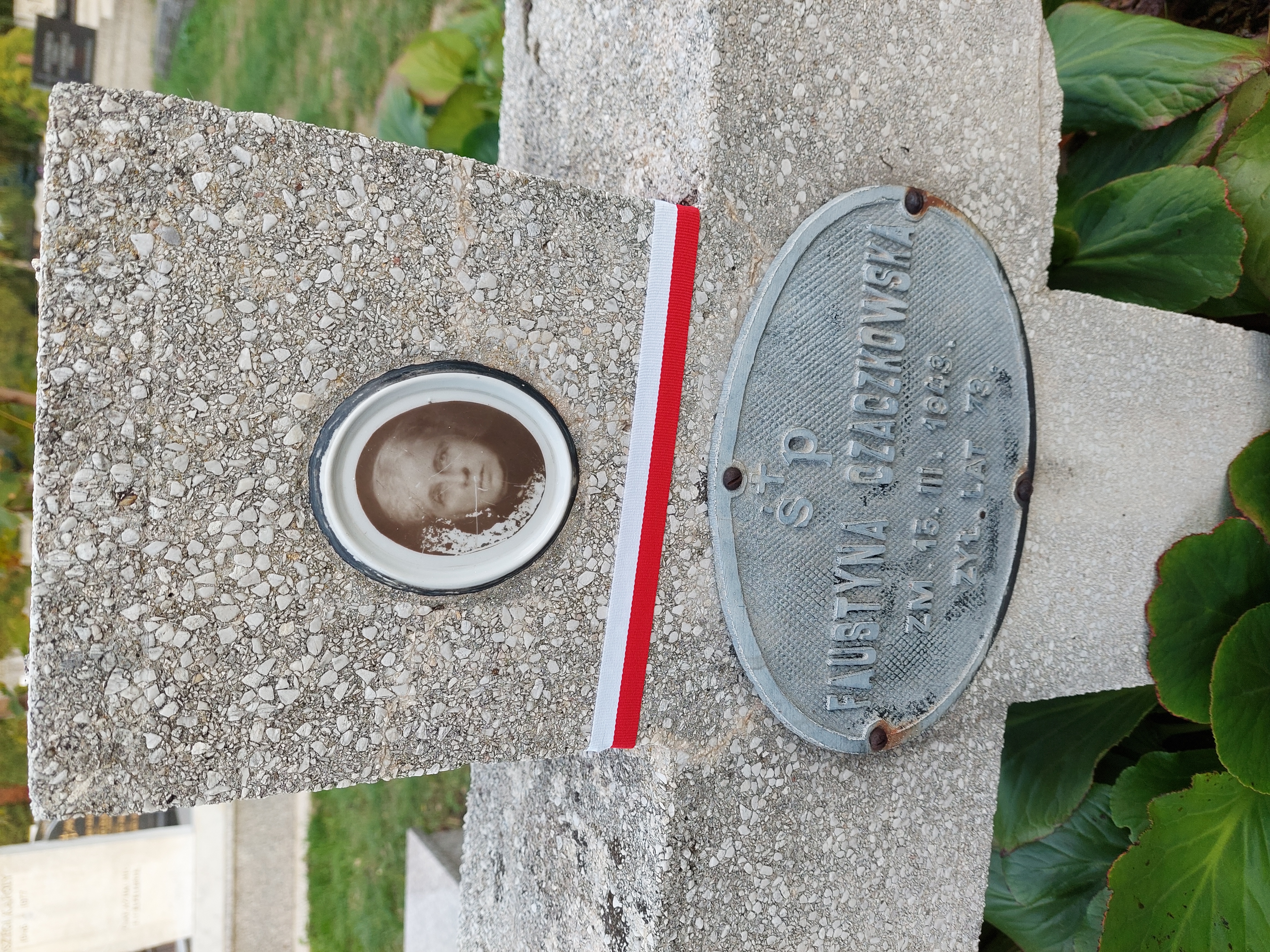 Grave of Faustyna Czaczkowska with a concrete cross, a photo of the deceased, and an inscription plate reading 'ŚP. Faustyna Czaczkowska, died 13.III.1943, aged 73'.
