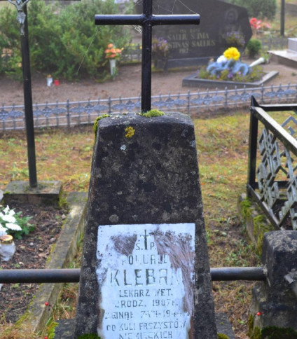 Grób Romualda Klebana, lekarza weterynarii, na cmentarzu katolickim w Święcianach. Grób zdobi betonowy obelisk z metalowym krzyżem i marmurową tablicą z jego imieniem i szczegółami śmierci w 1944 roku.