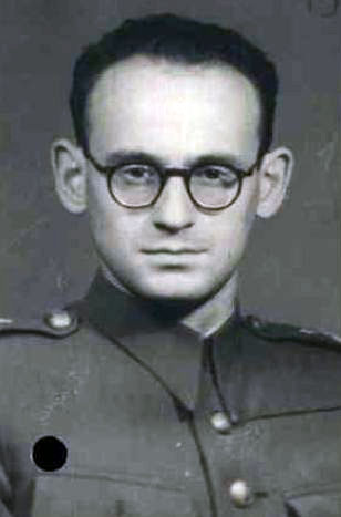 Black and white portrait of a man in military uniform with glasses, short hair and a serious expression.
