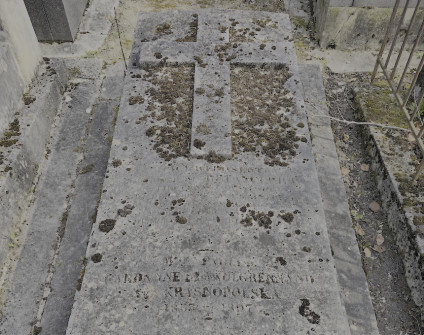 Nagrobek Alphonse’a de Betancourt i Pauliny Krasnopolskiej z cokolem schodkowym i skośną płytą z plastycznym krzyżem. Widoczna inskrypcja pod krzyżem.