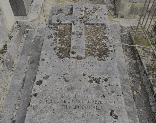 Nagrobek Alphonse’a de Betancourt i Pauliny Krasnopolskiej z cokolem schodkowym i skośną płytą z plastycznym krzyżem. Widoczna inskrypcja pod krzyżem.