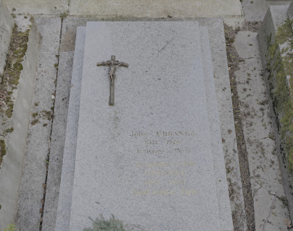 Nagrobek Jacquline i Johna Urbanków z płaską płytą, na której w lewym górnym rogu znajduje się krzyż i inskrypcja. Podstawa zawiera owalną żardiniere.