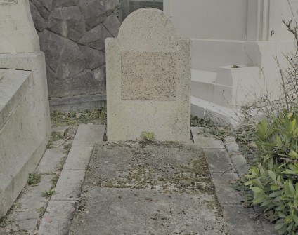 Miejsce grobowe z szerokimi płytami tworzącymi obramowanie, półokrągła stela z tablicą inskrypcyjną.