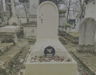 Tombstone of the Mirowski family with a Star of David, four black and white porcelain photographs, and inscriptions. A round marble plaque with a dove in flight motif lies on the slab.