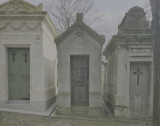 Kapliczka z trójkątnym dachem i napisem 'Famille Starzynski' nad drzwiami. Dekoracyjne drzwi żeliwne z motywami krzyża. Sąsiednie kapliczki w podobnym stylu architektonicznym.