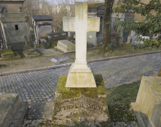 Nagrobek Michała Tyszkiewicza z wysokim krzyżem na kwadratowym postumencie. U podstawy wyryte gałązki laurowe i trzy płomienie. Na płycie widoczna inskrypcja.