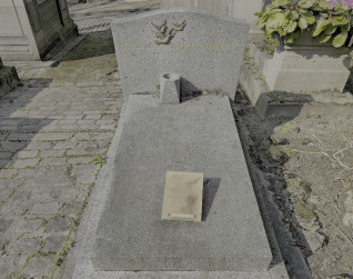 Nagrobek Madeleine i Maurycego Bartanowskich z ukośną granitową płytą i brązowym wazonem. Nad inskrypcją trzy brązowe gołębie z gałązkami oliwnymi.