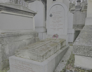 Nagrobek rodziny Skarbków i Poullierów, Jeanne Brousse i Jean-Pierre’a Dorgeta. Zawiera schodkowy cokół, pionową stelę z inskrypcjami i brązowy herb. Kwiaty u podstawy.