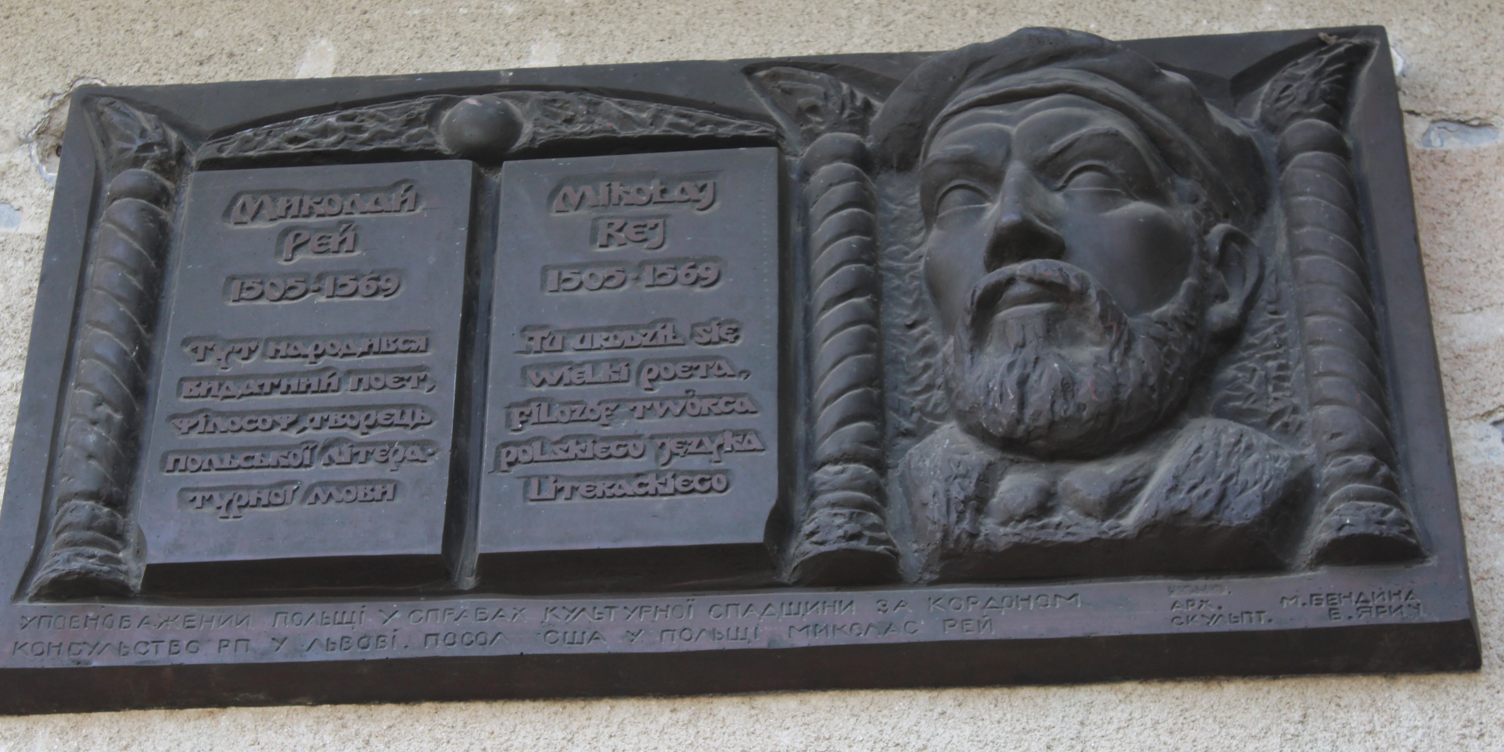 Plaque commémorative pour Mikołaj Rej sur le mur de l'ancien hôtel de ville à Żurawno, avec des inscriptions en polonais et en ukrainien, et un portrait en relief de Rej.