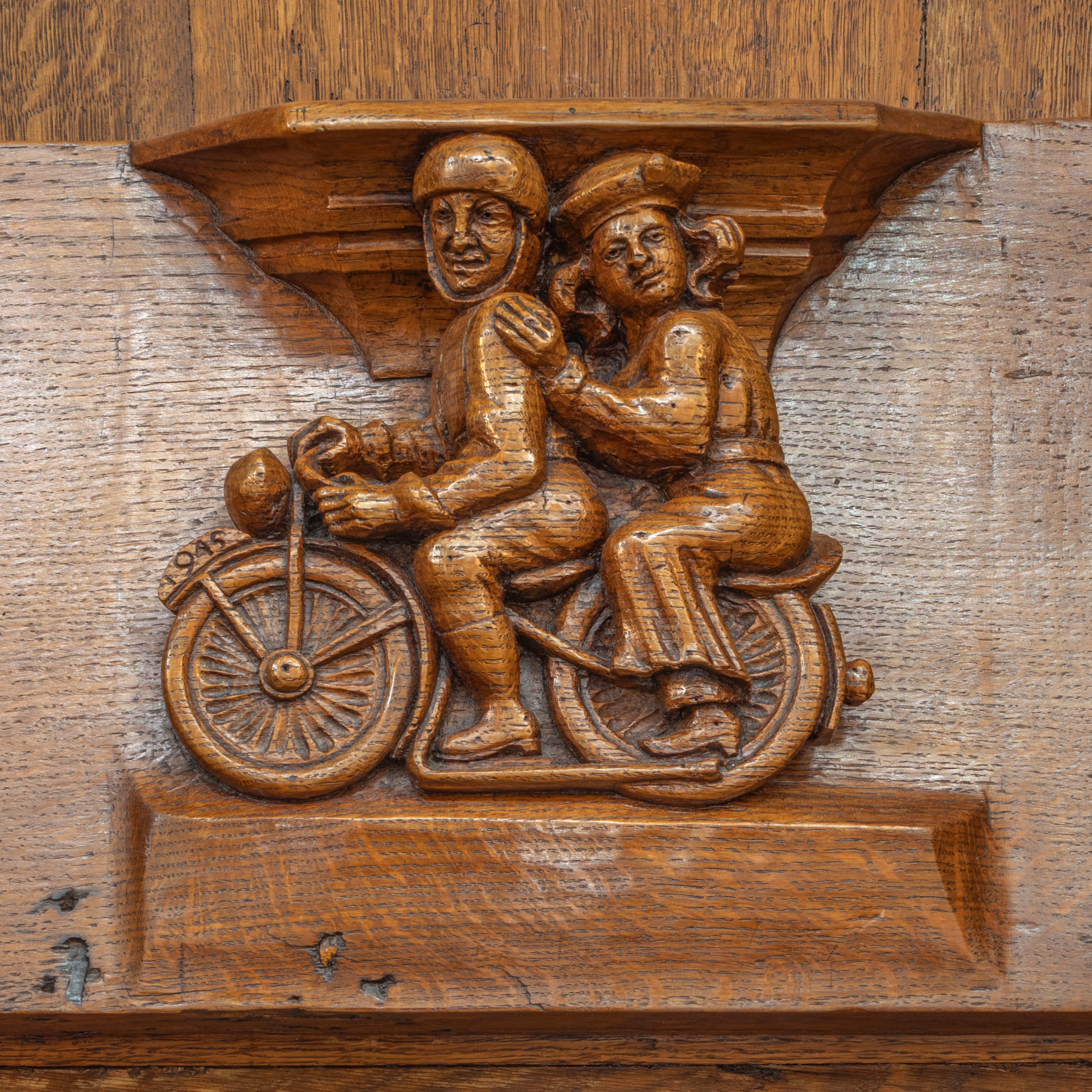 Wooden relief in the Church of Our Lady in Breda depicting a soldier and a woman on a motorcycle with the inscription '1945'.