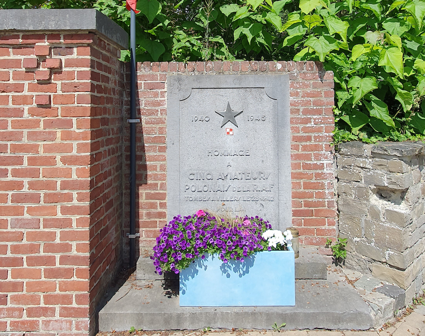 Plaque commémorative à Villers-la-Ville en l'honneur de cinq aviateurs polonais du 304e Escadron de la RAF. La plaque est encastrée dans un mur de briques avec une étoile et un emblème polonais, entourée de fleurs.