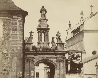 Brama Stanisława Augusta w Kamieńcu Podolskim z łukiem triumfalnym, na którym znajduje się figura św. Jana Nepomucena. Brama zdobiona pilastrami jońskimi i rzeźbami puttów.