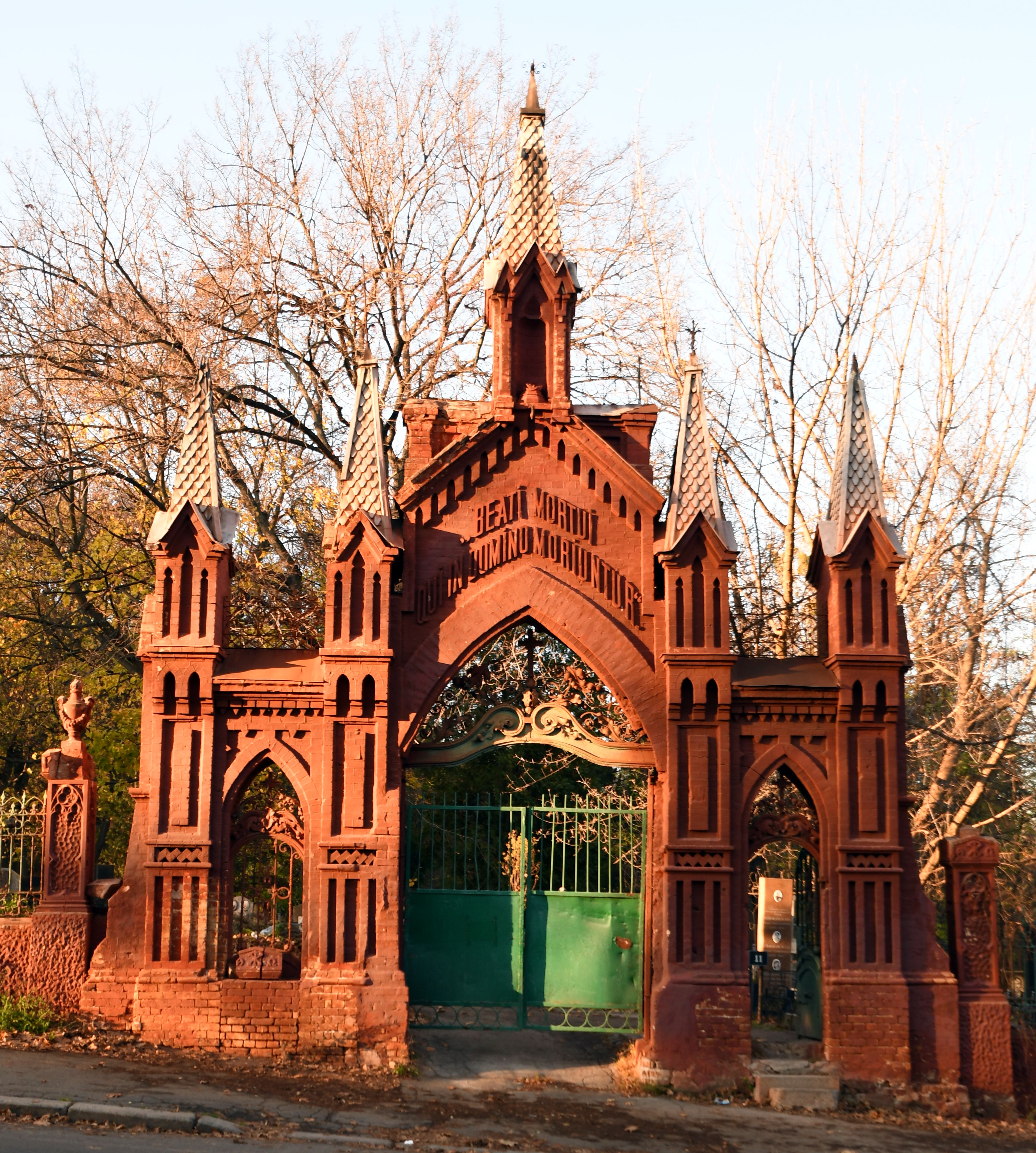 View from the front of the tall red brick cemetery gate