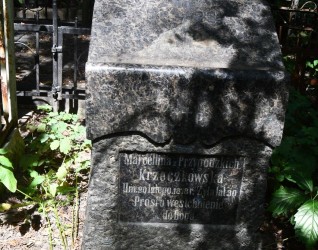 Nagrobek Marceliny Krzeczkowskiej z cokołem przypominającym pulpit. Na przedniej płycinie znajduje się ryta inskrypcja. Grób otoczony zielenią i metalowym ogrodzeniem.