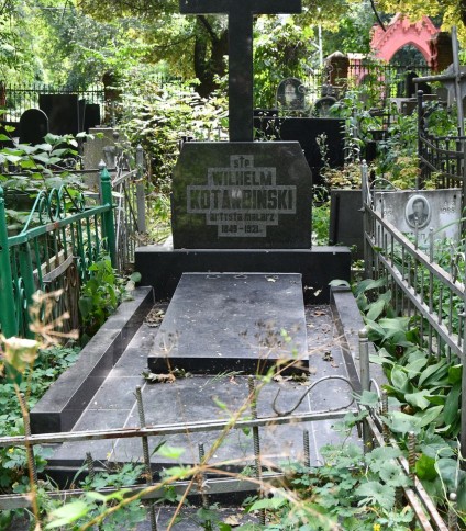 Grób Wilhelma Kotarbińskiego z prostokątną płytą nagrobną otoczoną dwoma blokami. Z płyty wznosi się krzyż z inskrypcją w reliefie. Otoczony zielenią i metalowym ogrodzeniem.