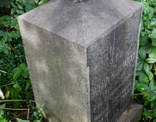 Nagrobek Juliana Radowickiego z niezachowanym krzyżem na cokole i podstawie. Podstawa i cokół mają ścięte górne krawędzie. Na przedniej płycinie z uszakami wyryta inskrypcja.