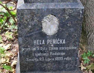 Nagrobek Heli Pěnička z inskrypcją w języku polskim, otoczony roślinnością. Kamień nosi ślady zużycia i ma pozostałości medalionu ze zdjęciem powyżej inskrypcji.