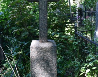 Nagrobek z krzyżem na cokole i podstawie, z mniejszym krzyżem wyrytym na przecięciu ramion. Cokół ma ścięte górne krawędzie i inskrypcję z przodu.