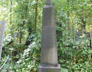 Nagrobek Kazimierza Drzewieckiego z krzyżem na wysokim cokole. Z przodu płycina z inskrypcją o zaokrąglonych narożach. Pomnik otoczony zielenią.