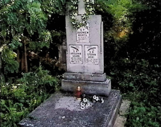 Grób Zbigniewa Hohola, Apolonii i Stefana Lehkich z dwustopniową płytą nagrobną na betonowej podstawie. Stela z prostym krzyżem i trzema tablicami z inskrypcjami. Otoczony zielenią.