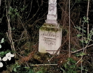 Nagrobek Teodora Melnyka z krzyżem, na którym znajduje się płaskorzeźba Chrystusa na przecięciu ramion. Cokół ma profilowane górne krawędzie i rytą inskrypcję z przodu.