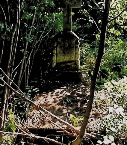 Nagrobek Agnieszki Mihalik z dwustopniową płytą i krzyżem na cokole w formie skałek. Krzyż ma żłobione lico i tablicę w formie zwoju z inskrypcją.