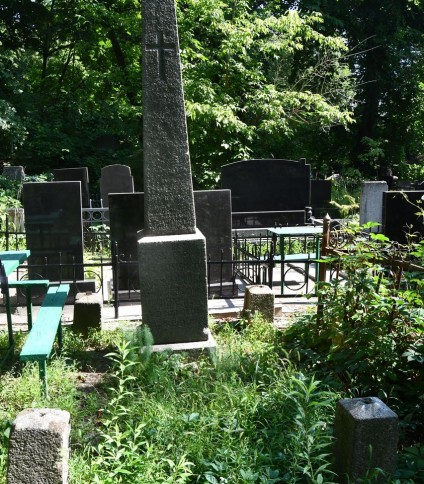 Grób oznaczony obeliskiem z wyrytym krzyżem, otoczony zarośniętą roślinnością. Podstawa i cokół mają ścięte krawędzie. Słupy narożne o przekroju kwadratu zakończone ostrosłupami.