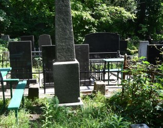 Grób oznaczony obeliskiem z wyrytym krzyżem, otoczony zarośniętą roślinnością. Podstawa i cokół mają ścięte krawędzie. Słupy narożne o przekroju kwadratu zakończone ostrosłupami.