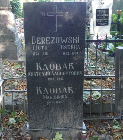 Nagrobek z inskrypcjami dla Piotra Berezowskiego, Ksenii Berezowskiej, Anatolija Al'bertowicza Klovaka i Maksymki Klovaka. Otoczony metalowym ogrodzeniem z dekoracyjnymi elementami i opadłymi liśćmi.