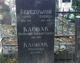 Nagrobek z inskrypcjami dla Piotra Berezowskiego, Ksenii Berezowskiej, Anatolija Al'bertowicza Klovaka i Maksymki Klovaka. Otoczony metalowym ogrodzeniem z dekoracyjnymi elementami i opadłymi liśćmi.