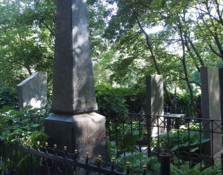 Nagrobek Emilii Ilnickiej oznaczony obeliskiem na dwustopniowym cokole z rytym napisem. Otoczony metalowym ogrodzeniem z dekoracyjnymi elementami. W tle drzewa i zieleń.