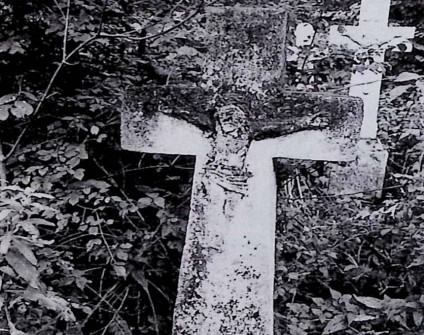 Nagrobek z krzyżem na cokole, szerszy u dołu. Na przecięciu ramion wypukłorzeźba Chrystusa. Cokół lekko zwęża się ku górze, z przodu inskrypcja.