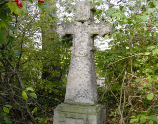 Nagrobek oznaczony krzyżem na cokole. Krzyż ma ramiona zakończone trójliściem z rozetą i płaskorzeźbą Madonny z Dzieciątkiem na przecięciu. Poniżej ryta inskrypcja. Cokół lekko zwęża się ku górze.