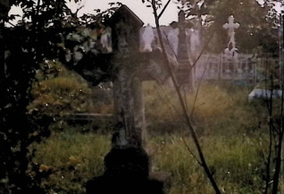 Grób oznaczony krzyżem na dwustopniowym cokole. Krzyż z ramionami zakończonymi romboidalnie i reliefem Chrystusa na przecięciu. Pierwszy stopień cokołu ma ścięte krawędzie, drugi pokryty szerszą, profilowaną płytą.