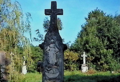 Nagrobek Teofili Piekarz z trójstopniową podstawą i krzyżem na szczycie. Krzyż z reliefem Chrystusa i inskrypcją. Poniżej nisza z reliefem Immaculaty otoczonej gwiazdami.