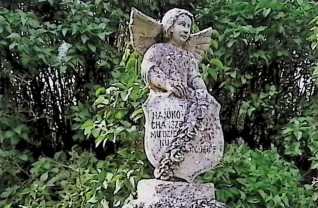 Nagrobek Tadeusza Wiesława Piernikarskiego z figurą anioła na kamiennym cokole. Anioł z rozpostartymi skrzydłami, w długiej sukni, trzyma tarczę z wieńcem kwiatowym i krzyżem. Inskrypcja na tarczy i tablicy w formie zwoju.