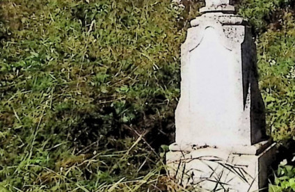 Grób oznaczony krzyżem na dwustopniowym cokole. Krzyż z ośmiobocznym dolnym ramieniem i płaskorzeźbą Chrystusa na przecięciu. Cokół z rzeźbionymi ramami i inskrypcjami.